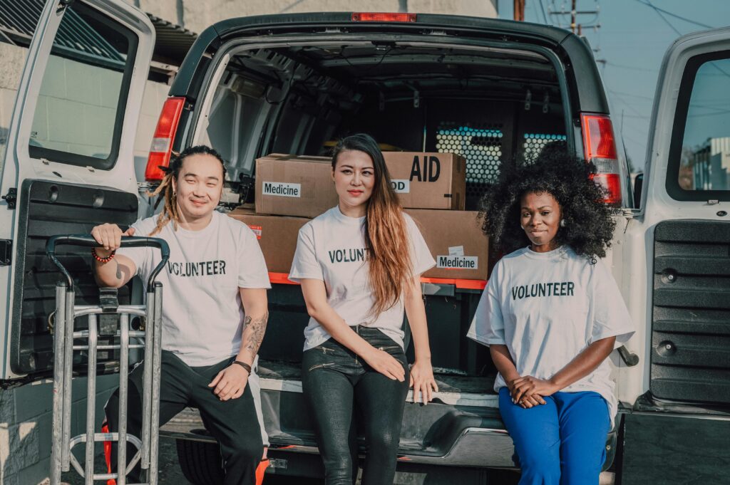 Volunteers organizing medicine and aid supplies for community distribution outdoors.
