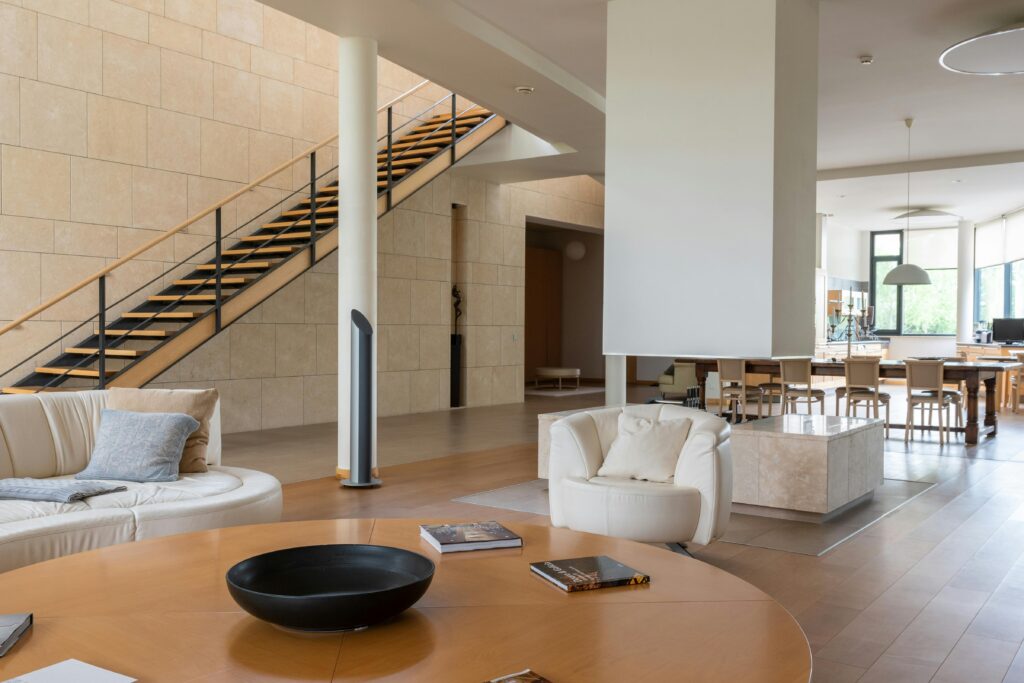 A luxurious and spacious modern living room featuring an open staircase and elegant furnishings.